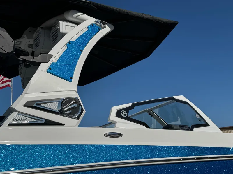 Slide: The Image of 2025 Tigé 24RZX boat with blue accents and sleek design under clear sky. - 5