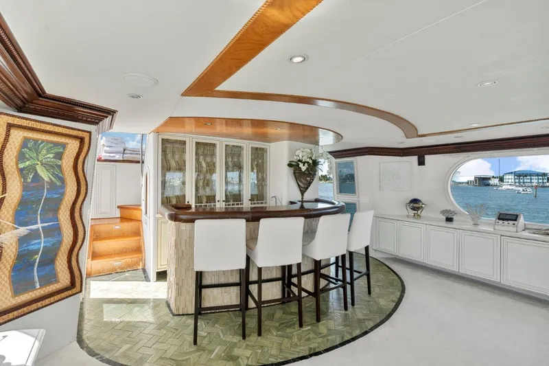 Slide: The Image of Luxurious interior of 1984 Broward 110 Motor Yacht with elegant bar and ocean view. - 16