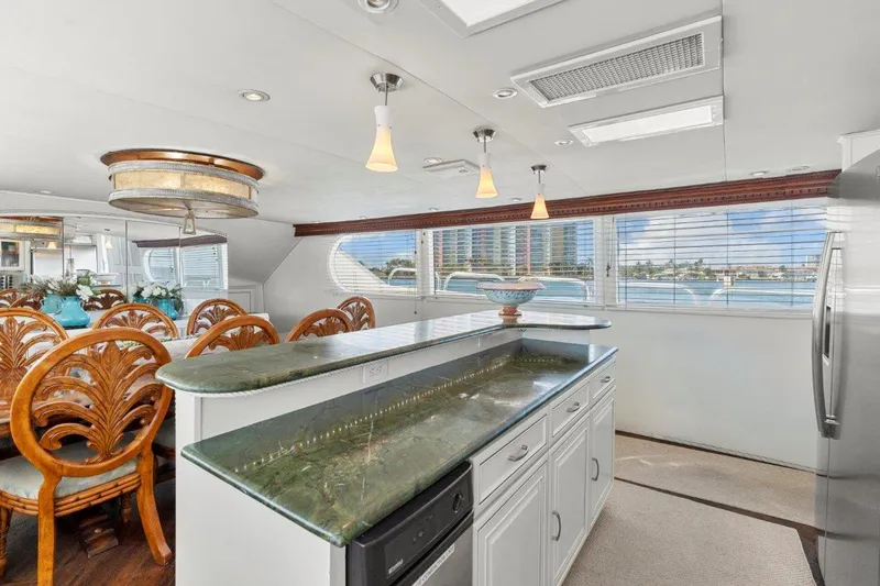 Slide: The Image of Luxurious interior of 1984 Broward 110 Motor Yacht with elegant dining area and modern kitchen. - 21