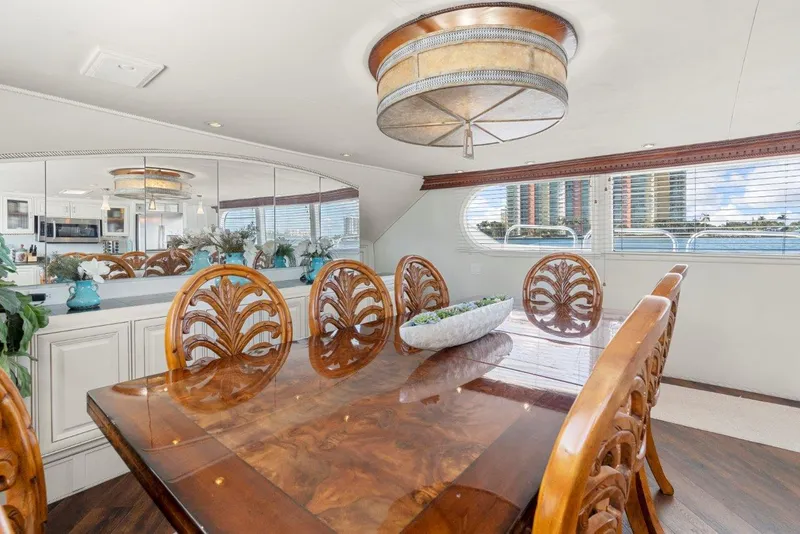 Slide: The Image of Luxurious dining area on 1984 Broward 110 Motor Yacht with elegant wood table and chairs. - 24