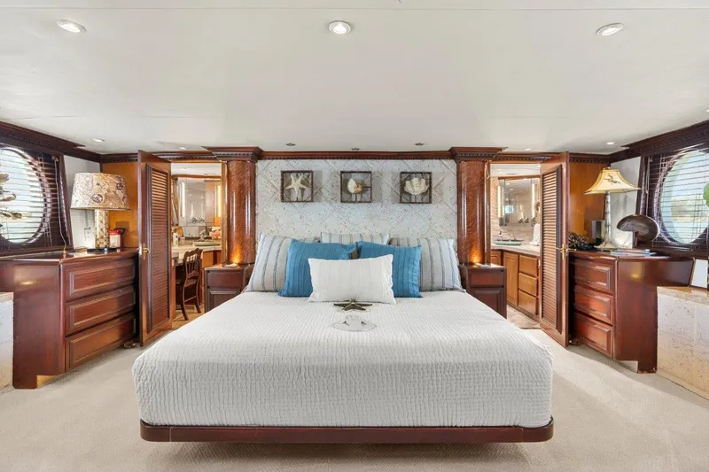 Slide: The Image of Luxurious bedroom interior of 1984 Broward 110 Motor Yacht with elegant wood accents. - 25