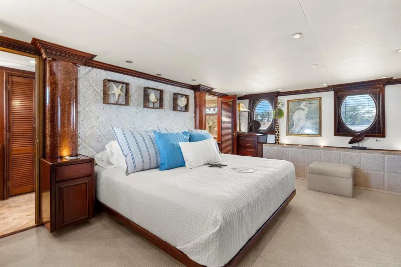 Slide: The Image of Luxurious bedroom interior on 1984 Broward 110 Motor Yacht with elegant decor and large bed. - 26