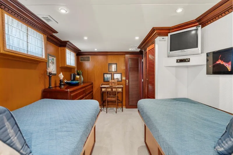 Slide: The Image of Interior of 1984 Broward 110 Motor Yacht with twin beds and wooden decor. - 35