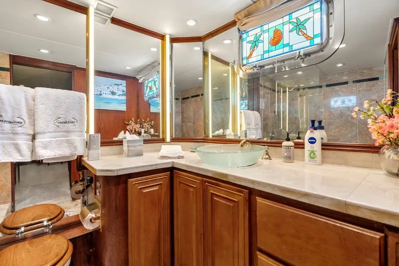 Slide: The Image of Luxurious bathroom on 1984 Broward 110 Motor Yacht with elegant wood cabinetry and stained glass window. - 36