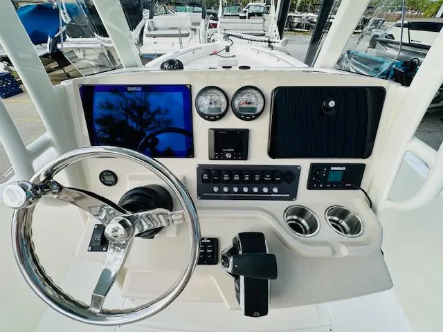 Slide: The Image of Boston Whaler 250 Dauntless 2025 helm with steering wheel, gauges, and control panel. - 19