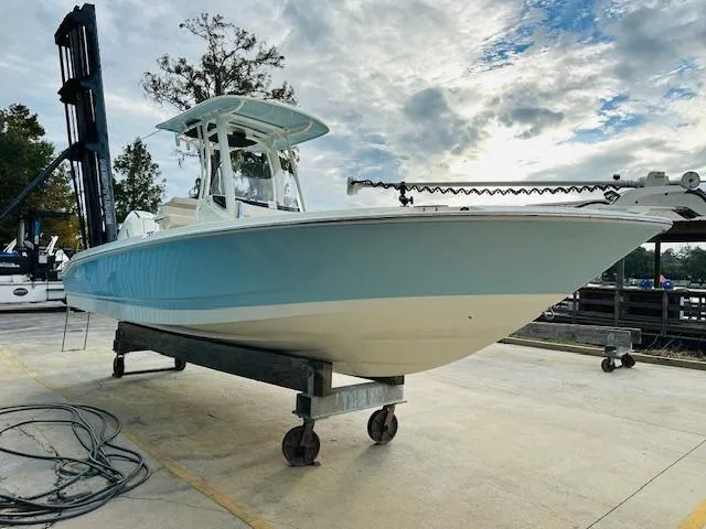 Slide: The Image of 2025 Boston Whaler 250 Dauntless boat on a lift, under a cloudy sky. - 5