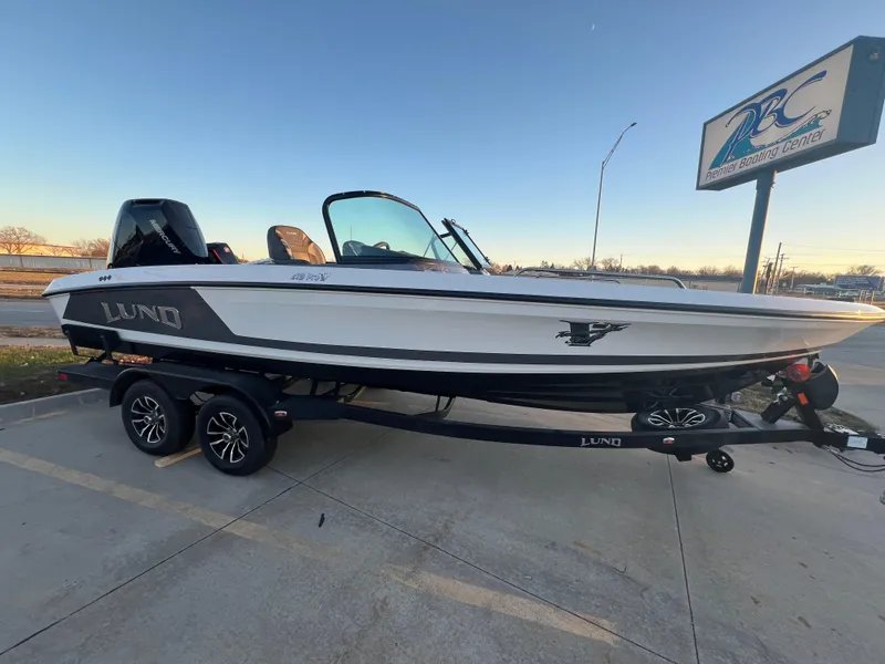 Slide: The Image of 2025 Lund 219 Pro-V GL boat on trailer at dealership parking lot. - 0