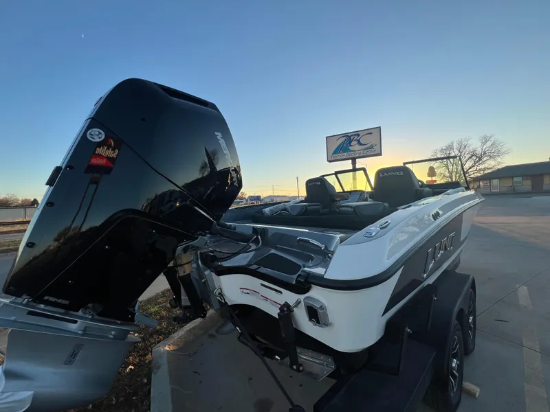 Slide: The Image of 2025 Lund 219 Pro-V GL boat with powerful outboard motor at sunset. - 12