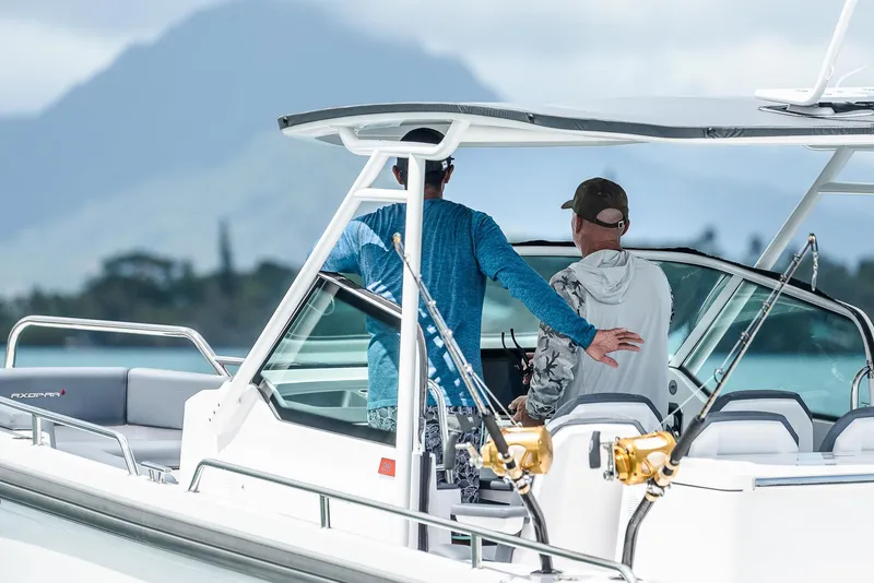 Slide: The Image of Two people on a 2023 Axopar 28 T-Top boat, scenic mountain backdrop. - 10