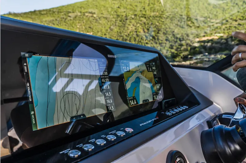 Slide: The Image of Axopar 28 T-Top 2023 dashboard with navigation screens and scenic background. - 2