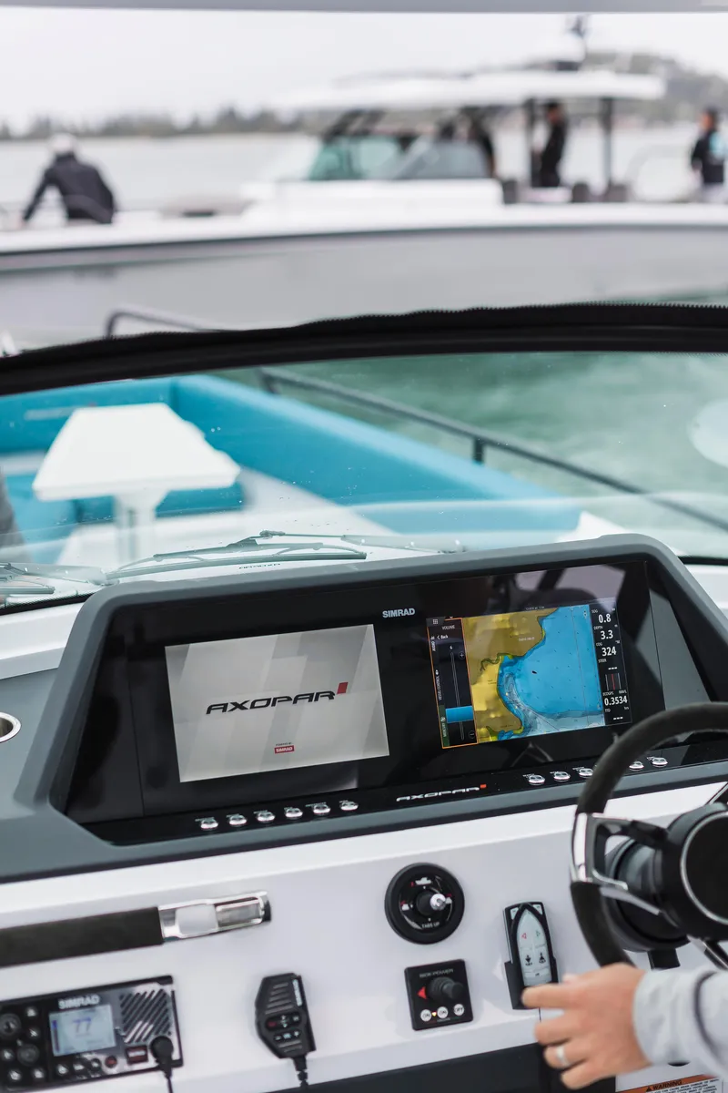 Slide: The Image of 2023 Axopar 28 T-Top boat dashboard with navigation display on water. - 3