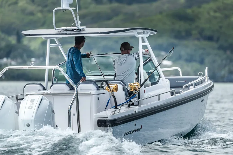 Slide: The Image of 2023 Axopar 28 T-Top boat with two people fishing on a lake. - 8