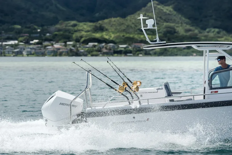 Slide: The Image of 2023 Axopar 28 T-Top boat cruising on water with fishing rods. - 9