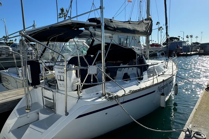The Image of 1992 Hunter 35 sailboat docked at marina, sunny day, calm waters. - 0
