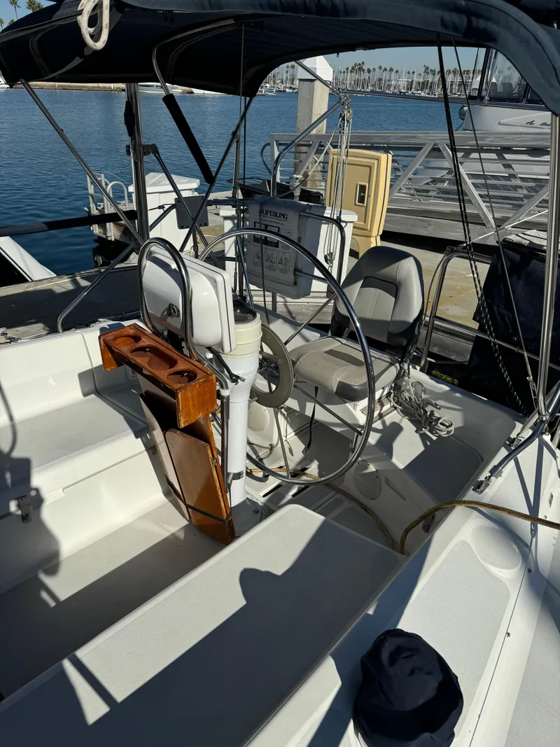 Slide: The Image of 1992 Hunter 35 sailboat cockpit with steering wheel, docked at marina. - 15