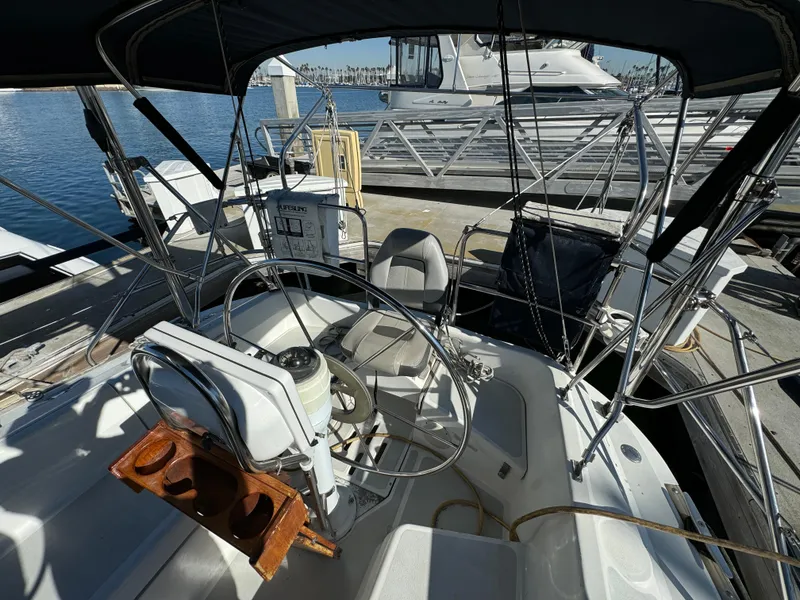 Slide: The Image of Cockpit of 1992 Hunter 35 sailboat docked at marina, featuring steering wheel and seating. - 17