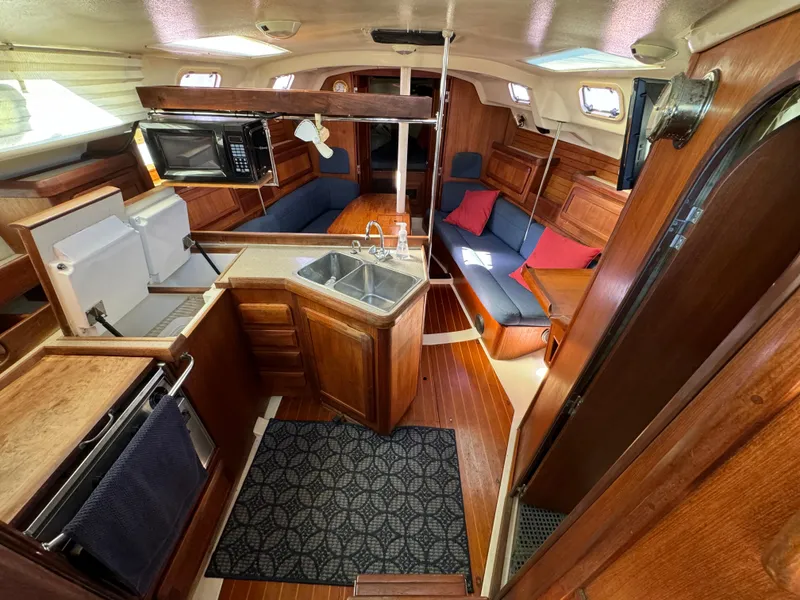Slide: The Image of Interior of 1992 Hunter 35 sailboat with kitchen, seating, and wooden finishes. - 38