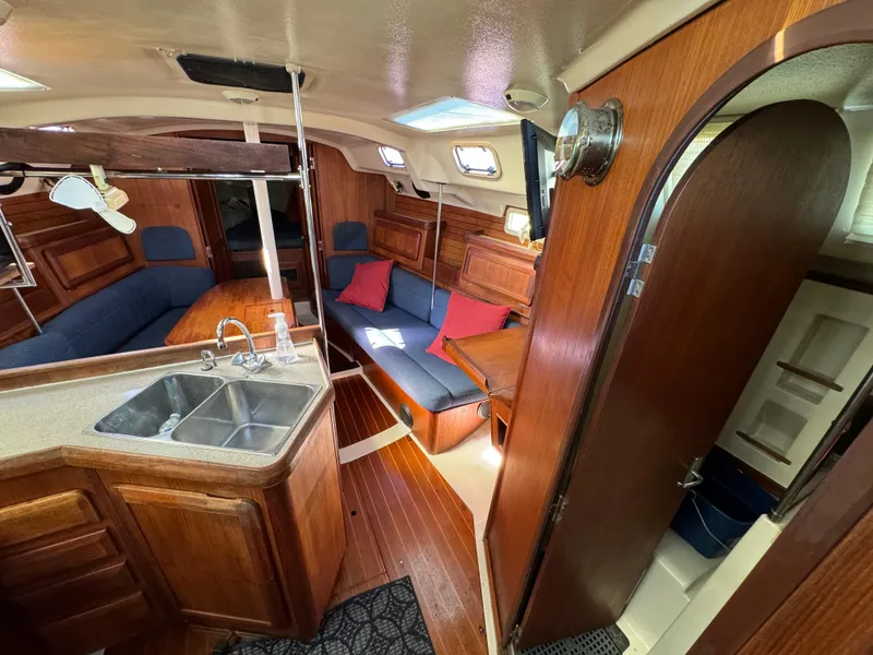 Slide: The Image of Interior of 1992 Hunter 35 sailboat with wood finish, kitchen, and seating area. - 40