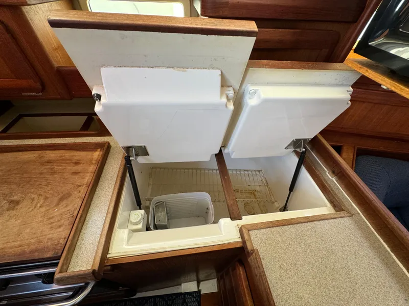 Slide: The Image of 1992 Hunter 35 yacht interior with open storage compartments in the galley area. - 42