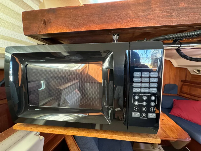 Slide: The Image of Microwave in a 1992 Hunter 35 yacht interior, wooden cabinetry, and seating area. - 45