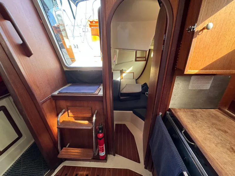 Slide: The Image of Interior of a 1992 Hunter 35 sailboat, featuring wooden cabinetry and compact living space. - 46