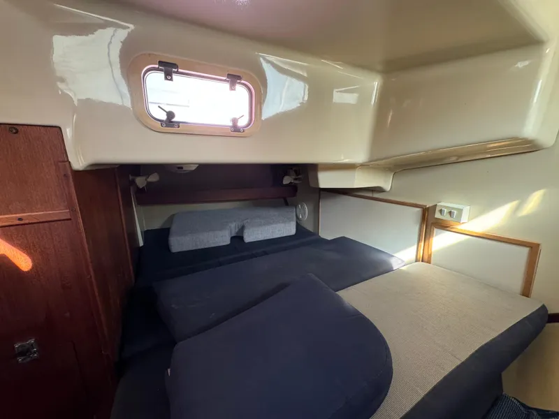 Slide: The Image of Cozy cabin interior of a 1992 Hunter 35 sailboat with bedding and a porthole. - 48