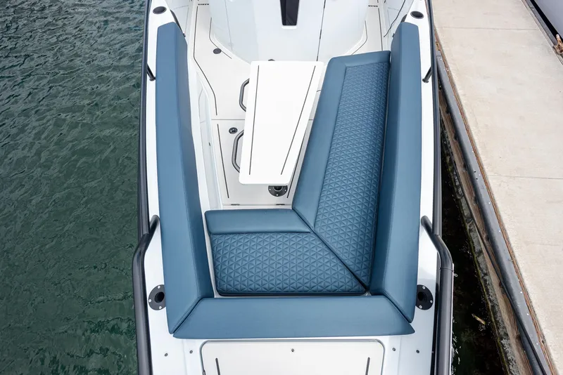Slide: The Image of 2023 BRABUS Shadow 500 T-Top AFT Cabin with blue seating, docked by the water. - 17