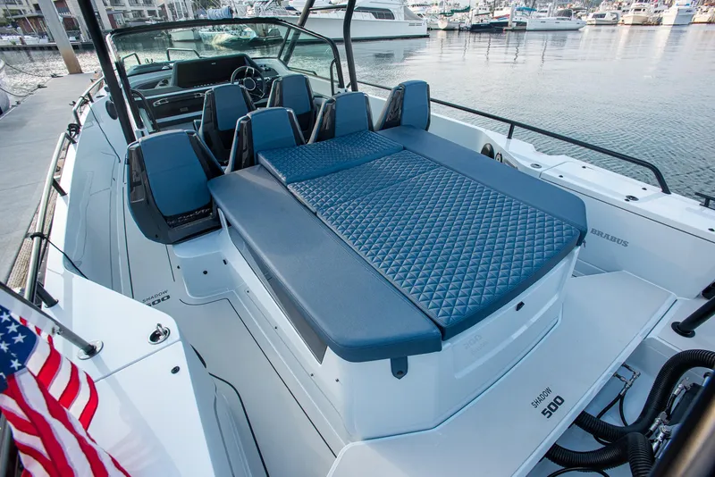 Slide: The Image of 2023 BRABUS Shadow 500 T-Top AFT Cabin with luxurious seating, docked at a marina. - 18