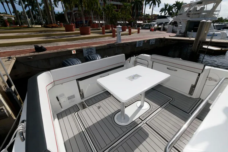 Slide: The Image of 2023 Jeanneau Leader 10.5 CC boat deck with table, docked at marina. - 10