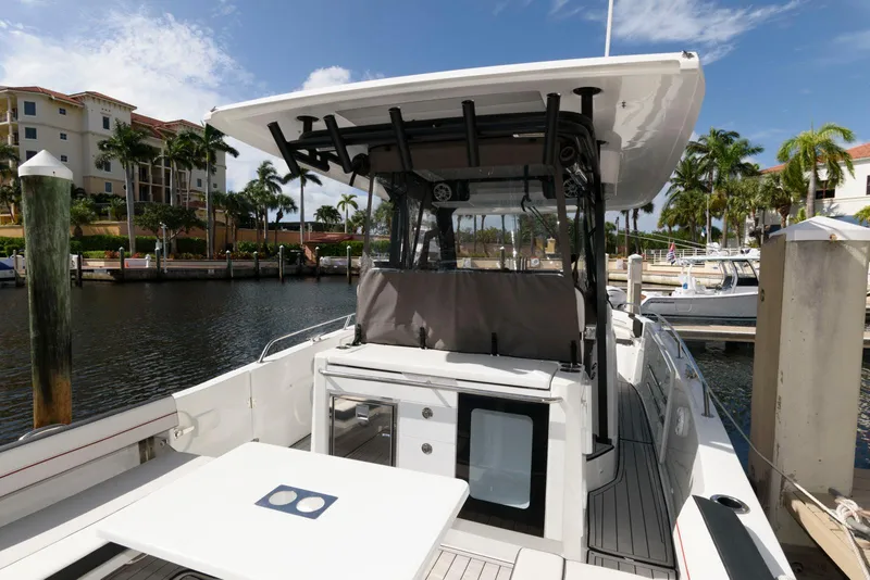 Slide: The Image of 2023 Jeanneau Leader 10.5 CC boat docked in a marina under a clear sky. - 11