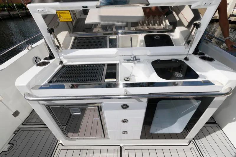 Slide: The Image of Outdoor kitchen on 2023 Jeanneau Leader 10.5 CC boat with grill, sink, and storage. - 12