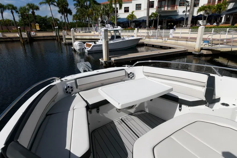 Slide: The Image of 2023 Jeanneau Leader 10.5 CC boat interior with seating and table at marina. - 20