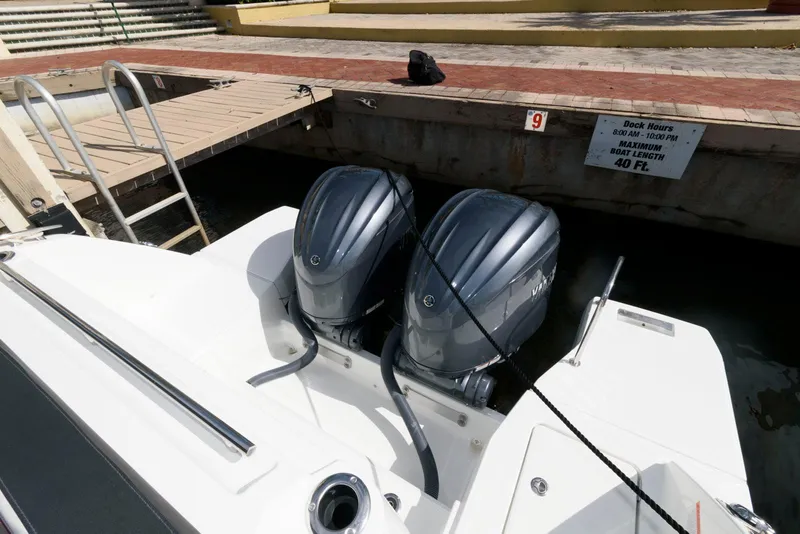 Slide: The Image of 2023 Jeanneau Leader 10.5 CC with dual outboard engines docked at marina. - 24
