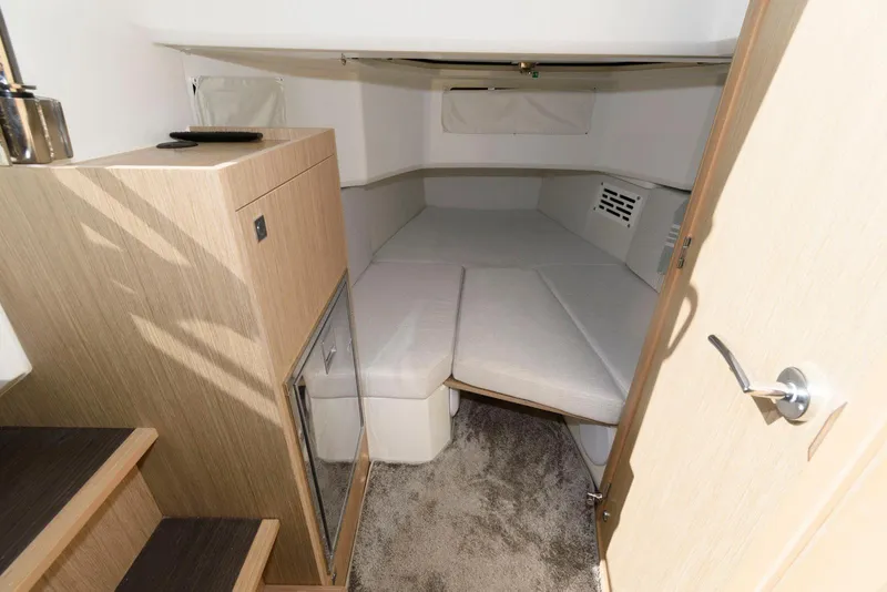 Slide: The Image of 2023 Jeanneau Leader 10.5 CC cabin interior with cozy bed and modern wood finish. - 25