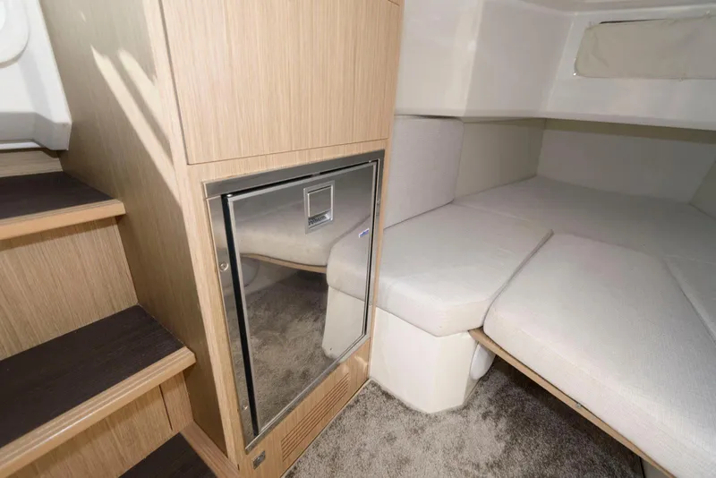 Slide: The Image of 2023 Jeanneau Leader 10.5 CC cabin interior with compact fridge and cozy seating area. - 28