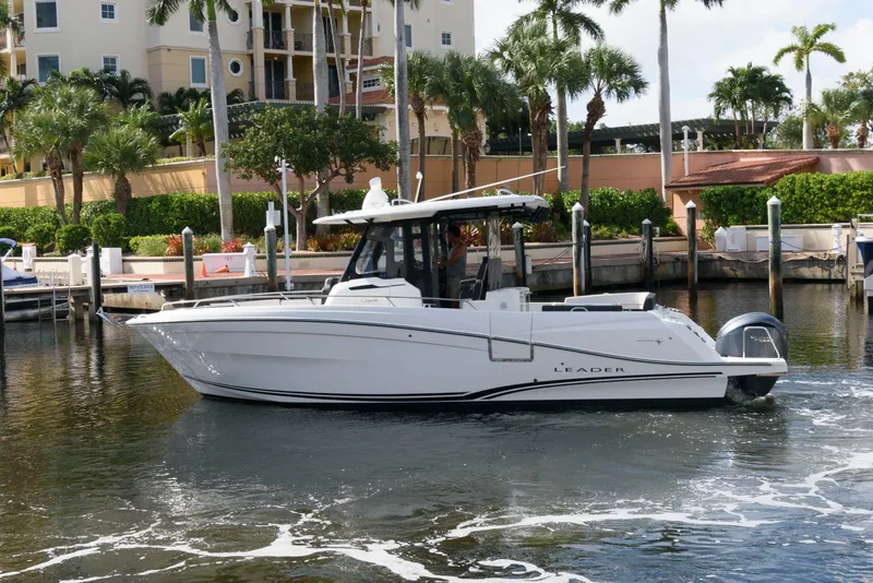 Slide: The Image of 2023 Jeanneau Leader 10.5 CC boat docked in a marina with palm trees. - 3