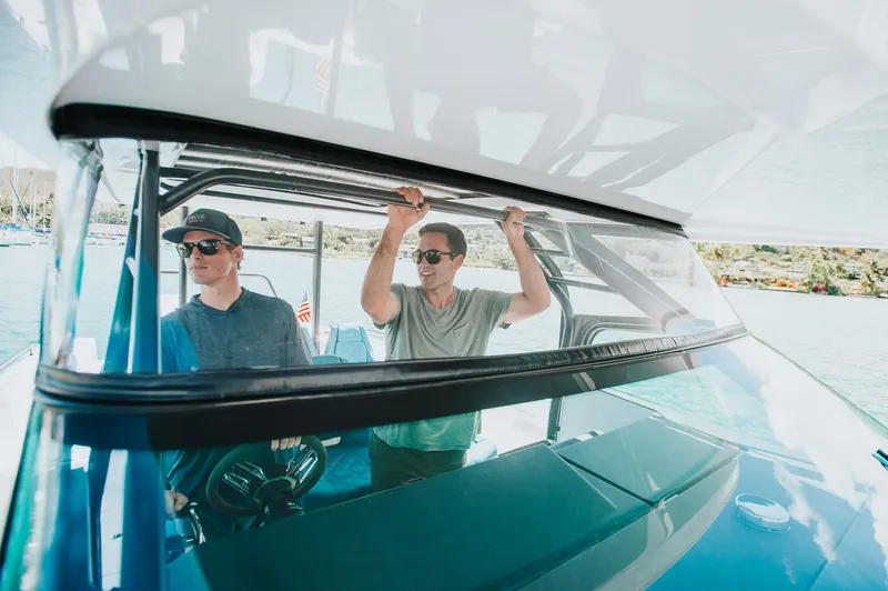 Slide: The Image of Two people on a 2023 Axopar 37 Sun-Top Wet Bar boat, enjoying a sunny day. - 14