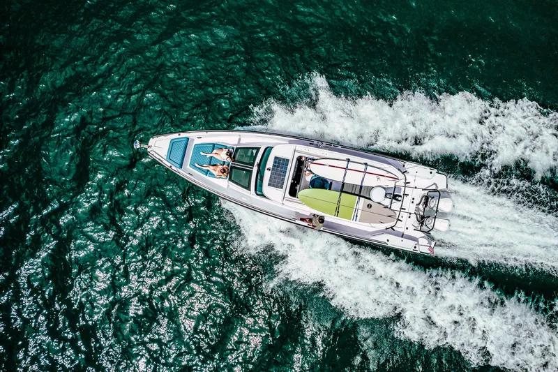 Slide: The Image of Aerial view of 2023 Axopar 37 Sun-Top Wet Bar cruising on vibrant blue water. - 15