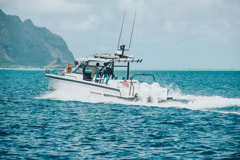 Slide: The Image of 2023 Axopar 37 Sun-Top Wet Bar cruising on ocean near scenic coastline. - 16