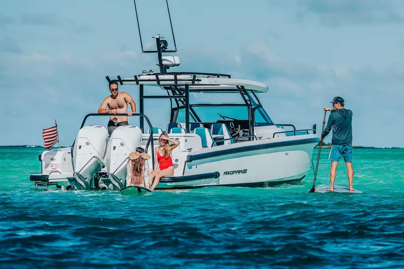 Slide: The Image of 2023 Axopar 37 Sun-Top Wet Bar on turquoise water with people enjoying leisure activities. - 17