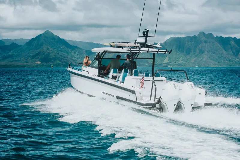 Slide: The Image of 2023 Axopar 37 Sun-Top Wet Bar cruising on scenic ocean with mountains. - 19