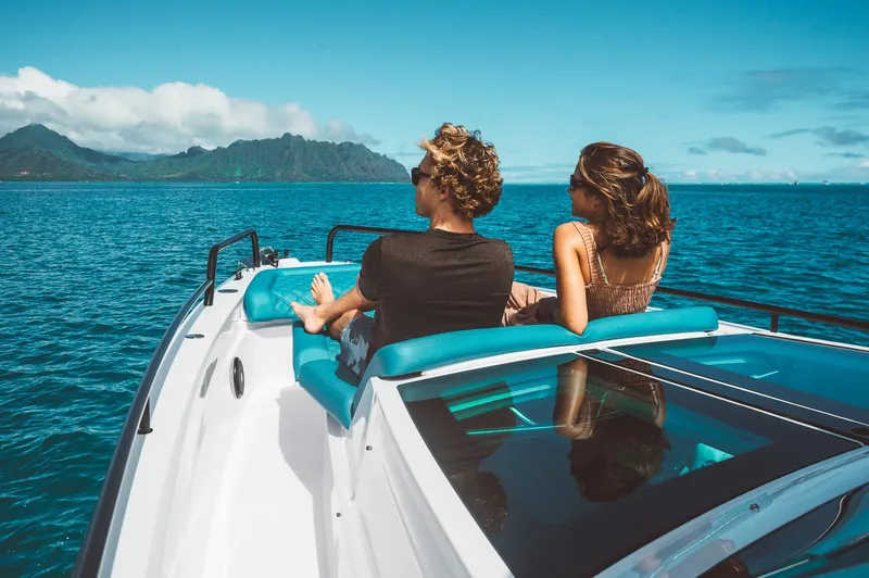 Slide: The Image of Couple relaxing on 2023 Axopar 37 Sun-Top Wet Bar boat, scenic ocean view. - 2