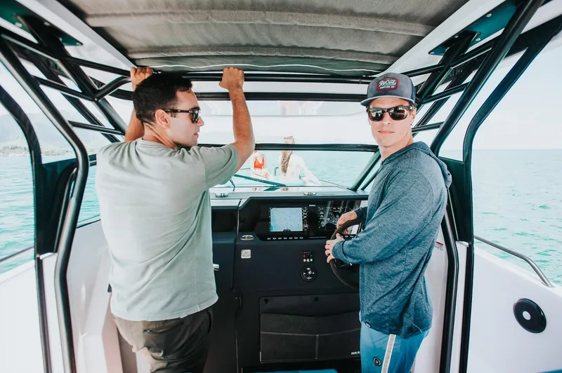 Slide: The Image of Two people on a 2023 Axopar 37 Sun-Top Wet Bar boat. - 5