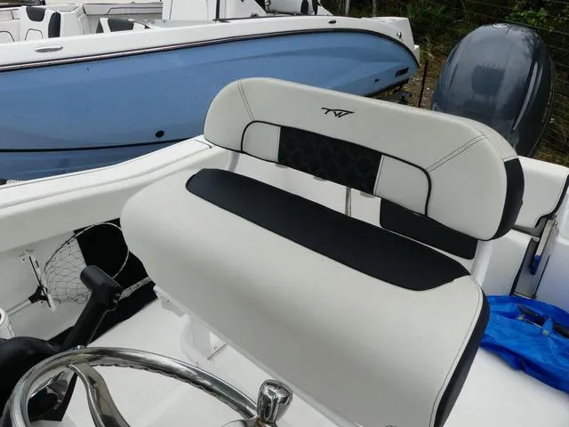 Slide: The Image of 2023 Tidewater 210 CC Adventure boat interior with sleek seating and steering wheel. - 10
