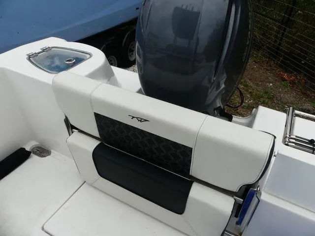 Slide: The Image of 2023 Tidewater 210 CC Adventure boat with sleek seating and powerful outboard motor. - 11