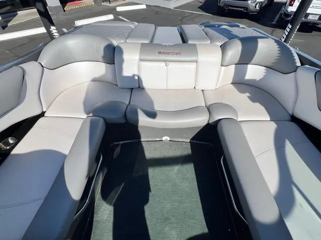 Slide: The Image of 2012 MasterCraft X25 boat interior with gray seating and logo. - 14