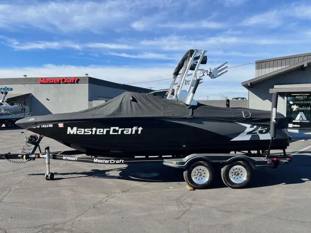 Slide: The Image of 2012 MasterCraft X25 boat on trailer, covered, parked outdoors. - 20