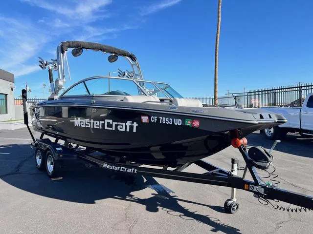 Slide: The Image of 2012 MasterCraft X25 boat on trailer, parked outdoors under clear blue sky. - 4