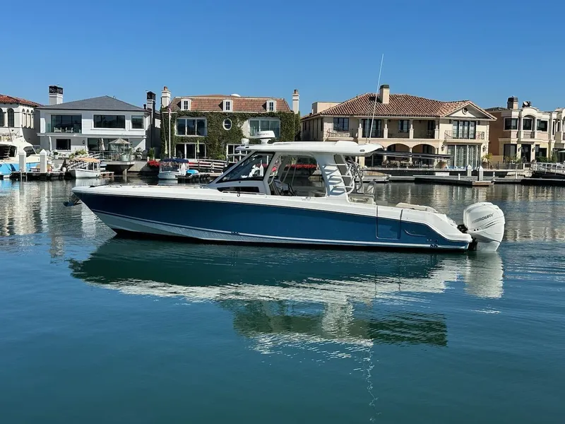 Slide: The Image of 2019 Boston Whaler 350 Realm boat docked in a scenic marina. - 1