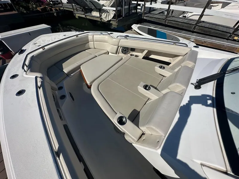 Slide: The Image of 2019 Boston Whaler 350 Realm boat interior with cushioned seating and cup holders. - 15